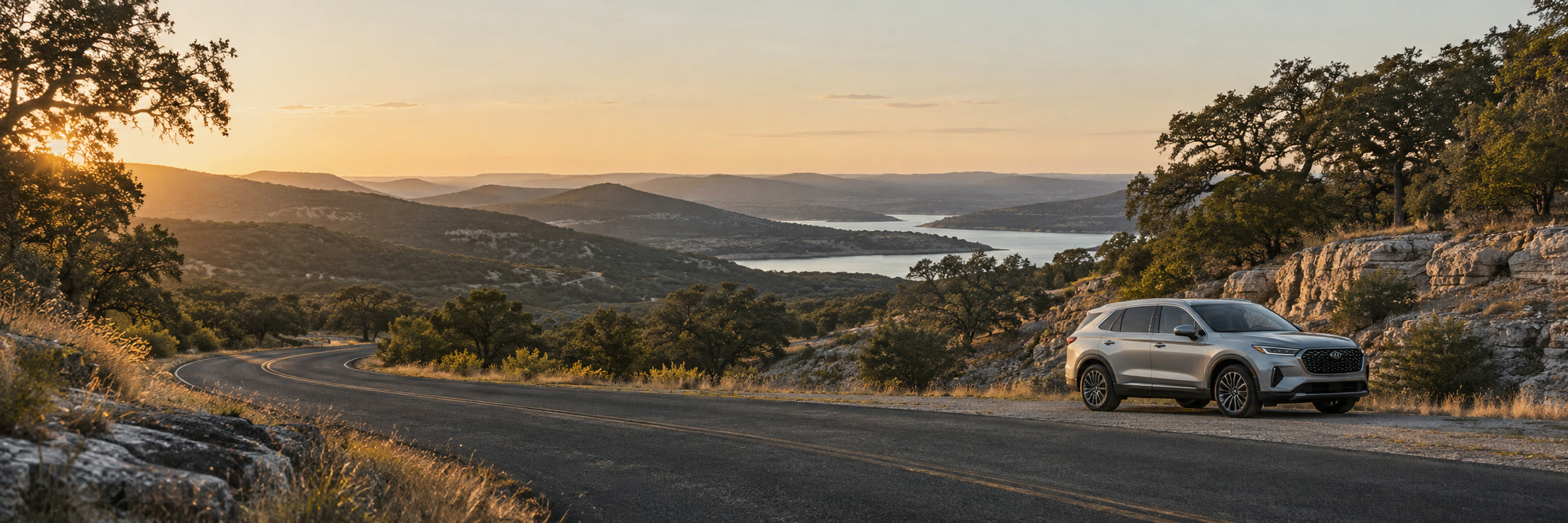 A silver SUV on a winding road through the Texas Hill Country